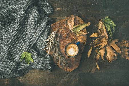 Autumn morning coffee concept with leaves and grey sweater