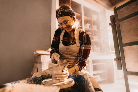 Female potter making clay pot