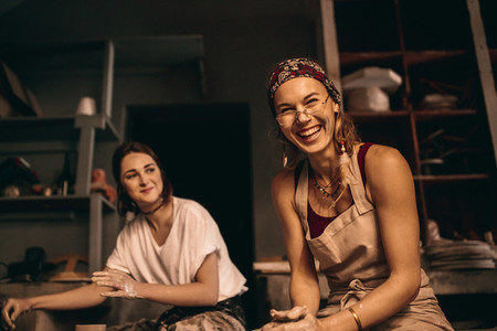 Two women at a pottery workshop moulding clay