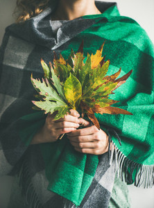 Woman in check scarf or blanket with Autumn leaves