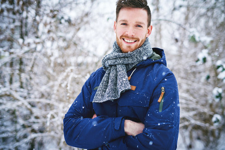 Laughing man in coat on snowy background