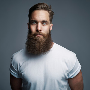Serious young muscular man with large fuzzy beard