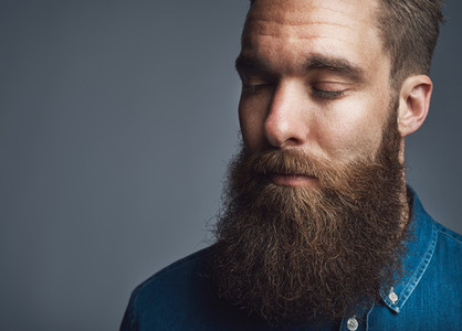 Bearded man in blue denim with eyes closed