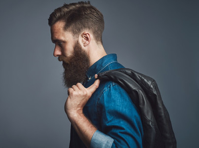 Side view on bearded man holding black jacket