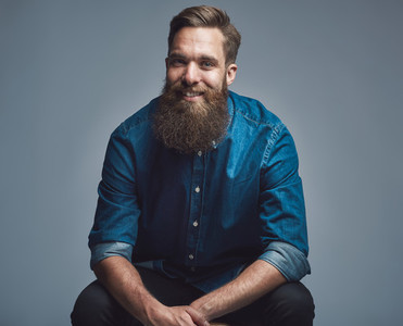 Handsome smiling man in blue shirt and beard