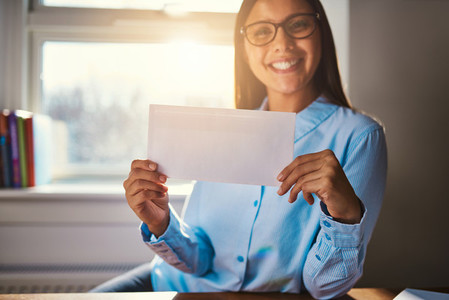 Woman sitting at desk with blank envelope