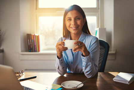 Woman working at office drinking coffee
