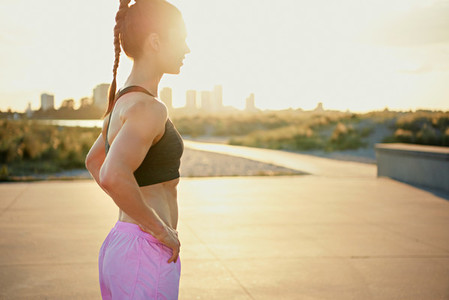 Toned fit young woman backlit by the sunrise