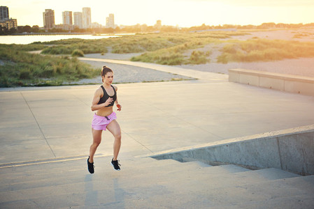Fit young woman jogging up a flight of stairs