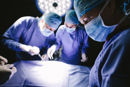 Surgeons performing surgery in operating theater