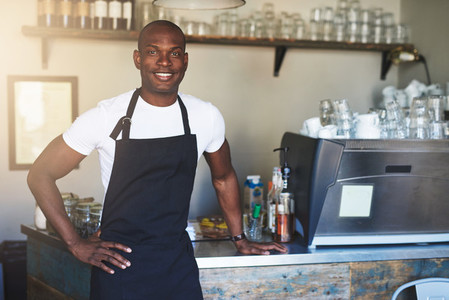 Confident male coffee house owner at counter