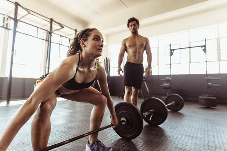 Female athlete lifting weights at cross training gym