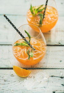 Refreshing cold alcoholic summer cocktail with orange in glasses
