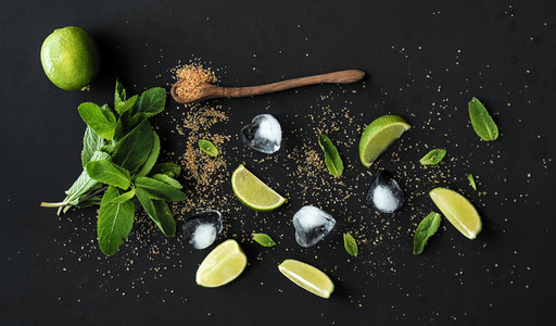 Ingredients for mojito Fresh mint limes ice sugar over black backdrop