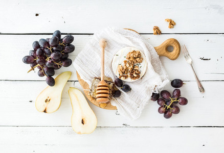 Camembert cheese with grape  walnuts  pear and honey on vintage metal plate