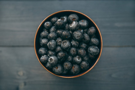 Bowl of blueberries on wood table