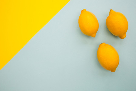 Bunch of fresh lemons on blue and yellow background