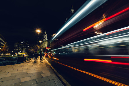 City light trails of moving red London bus at night