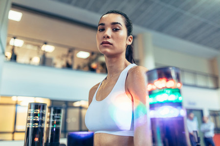 Sportswoman at gym with lights around