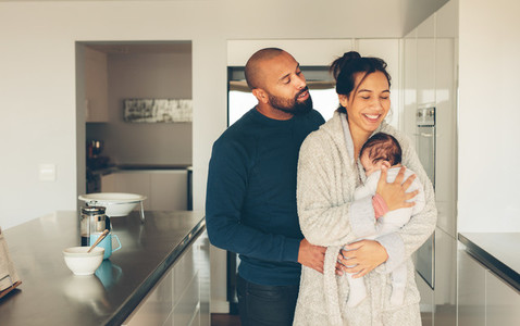 Couple with their little baby boy in kitchen