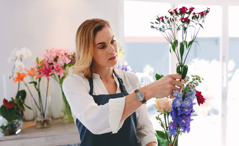 Female working at flower shop arranging flowers