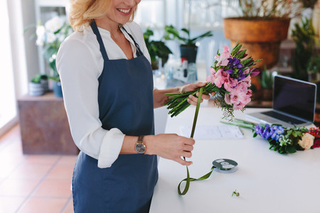 Female florist creating bouquet at shop