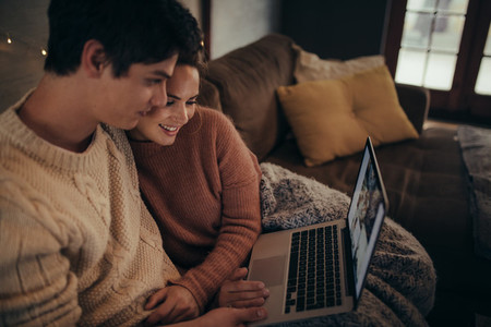 Couple using laptop in hygge house