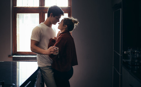 Affectionate young couple together in kitchen