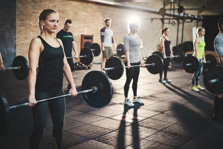 Group of adults holding heavy barbells