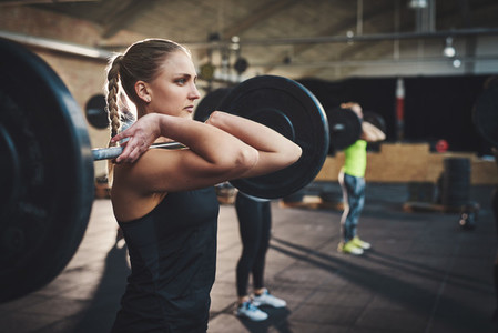 Woman pulling up large barbell in fitness class