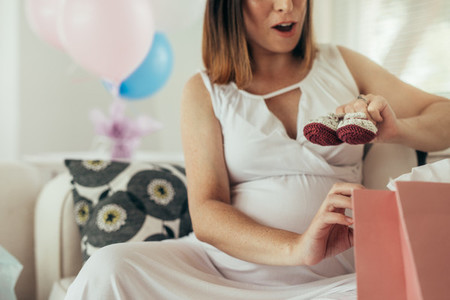 Pregnant woman opening presents after baby shower
