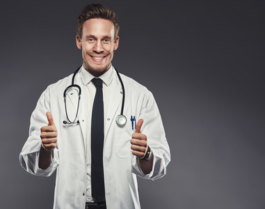 Enthusiastic doctor giving the thumbs up against a grey background