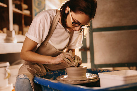 Female potter making a clay bowl