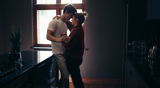 Loving young couple embracing at kitchen counter