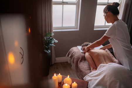 Woman receiving body massage at spa center