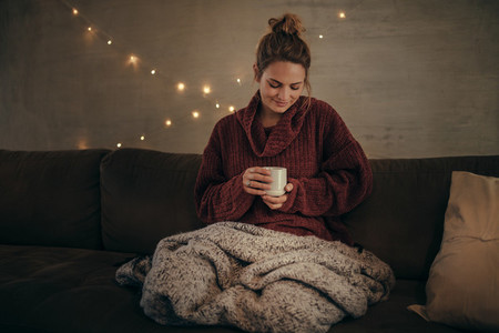 Relaxed woman drinking coffee in winter at home