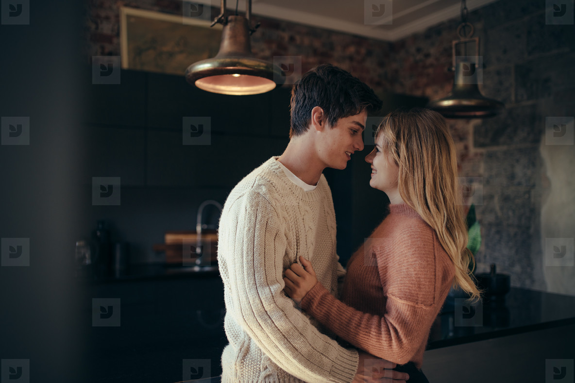 Romantic young couple embracing in kitchen