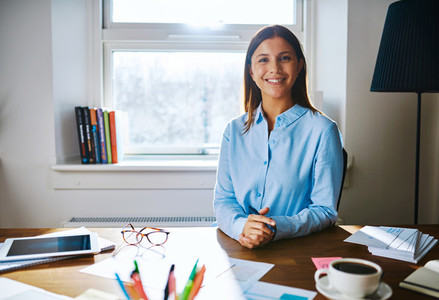 Confident smiling woman at desk