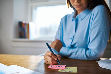 Close up of person writing on sticky notes