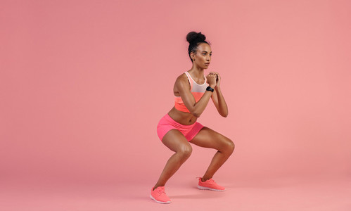 Sporty woman practicing squat exercise