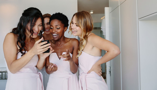 Bridesmaids using mobile phone on the wedding day