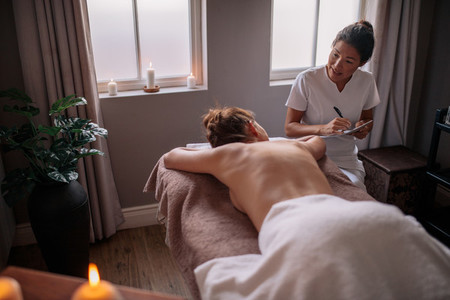 Massage therapist talking to wom