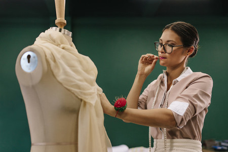 Female designer working on mannequin