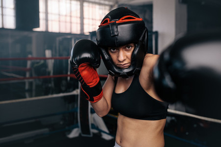 Female boxer in action inside the boxing ring