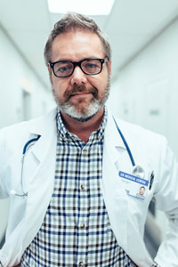 Portrait of mature doctor standing in hospital