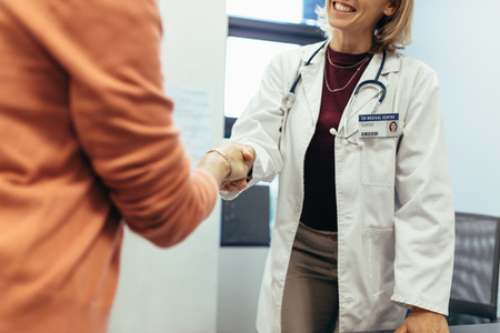 Friendly doctor shaking hands with patient