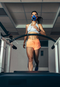 Runner with mask on treadmill in sports science laboratory