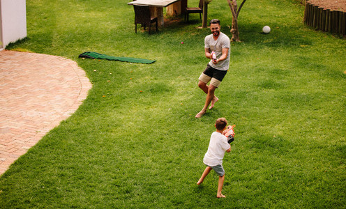 Father and son having fun with water guns outdoors