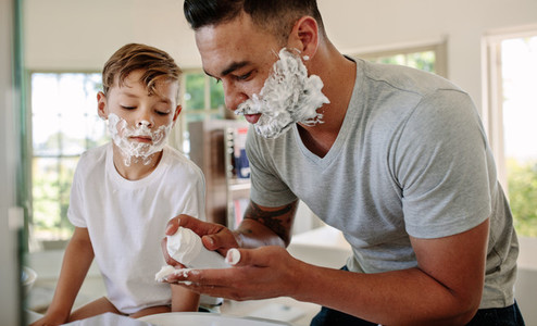 Father and son applying shaving foam on their faces