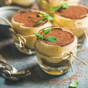 Homemade Italian dessert Tiramisu served in individual glasses square crop